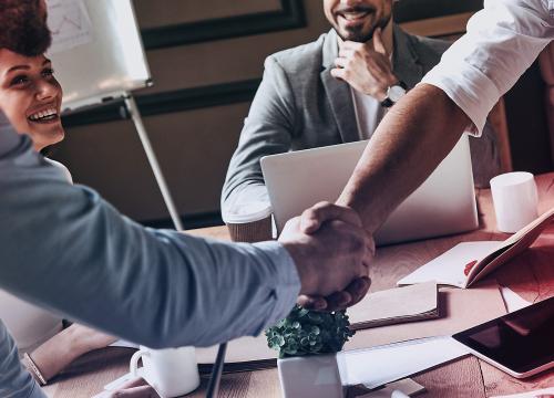 Gruppe im Büro Händeschütteln